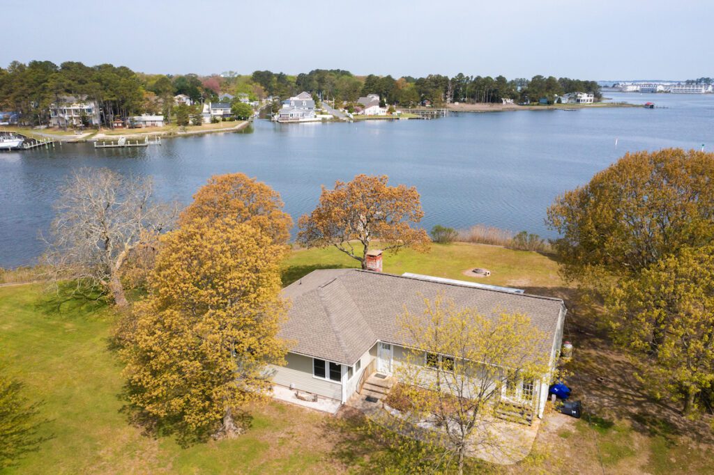 A ranch-style home surrounded on three sides by water. The spacious back yard includes a private dock.
