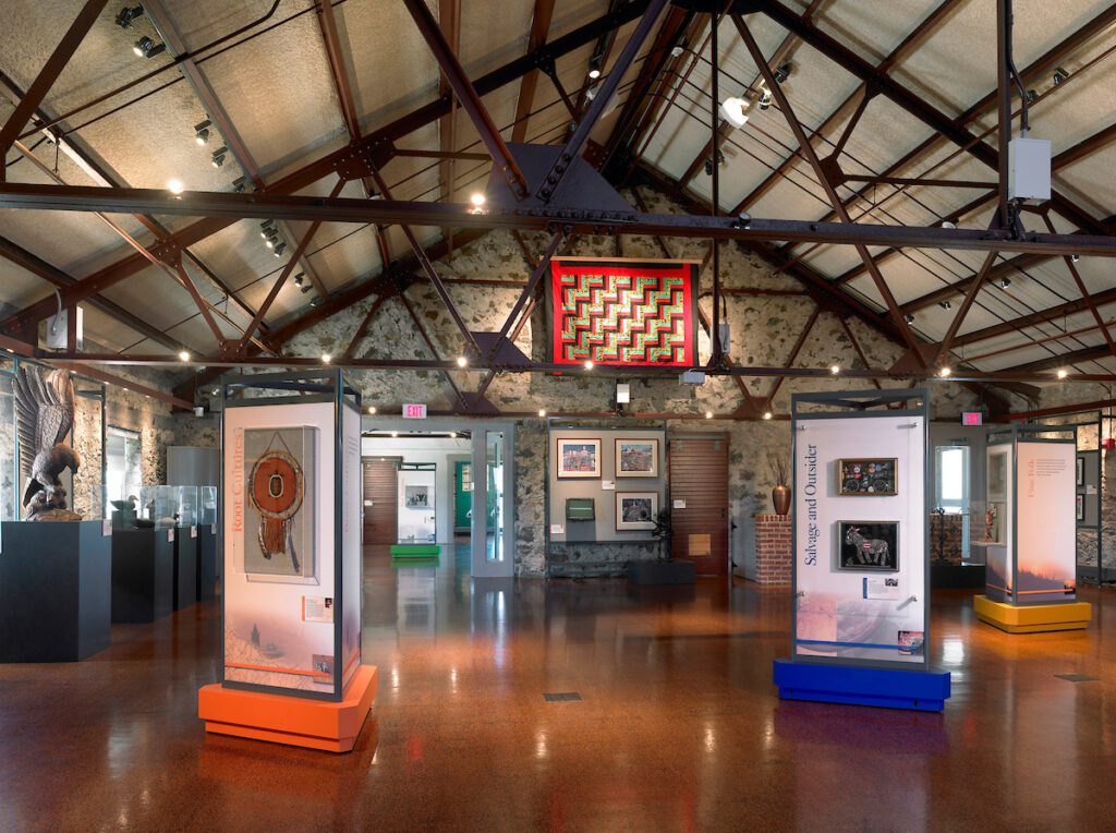 Interior showcasing an art exhibition with display cases and artworks.